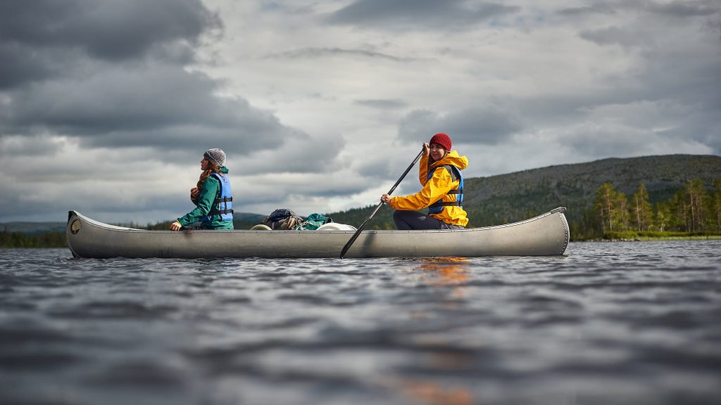 Girl relaxing in a canoe on a Norwegian lake