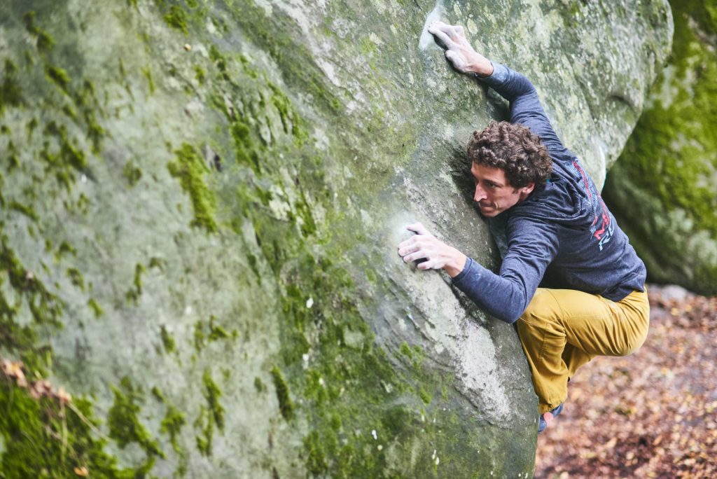 Guillaume Glairon Mondet climbing a hard boulder problem in Fontainebleau