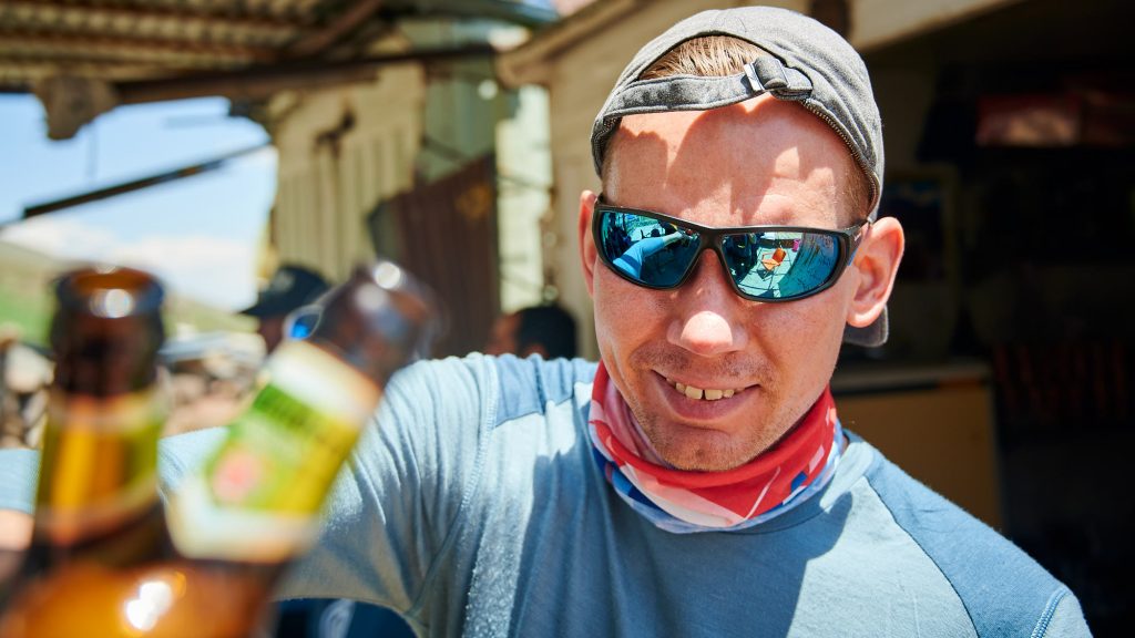 Climber celebrating a successful climb with a non-alcoholic beer in Iran