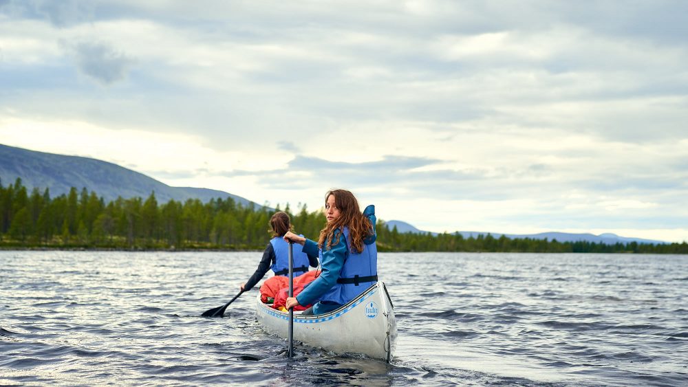 Two girls in a canoe on a lake in Norway