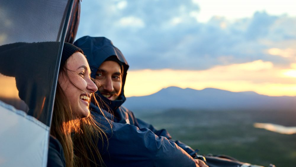 Couple in a tent on a mountain in Norway, with an epic view of the landscape