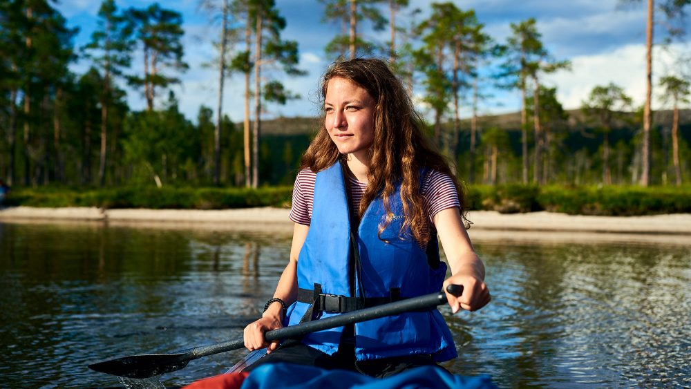 Traveller in a canoe on a lake in Norway