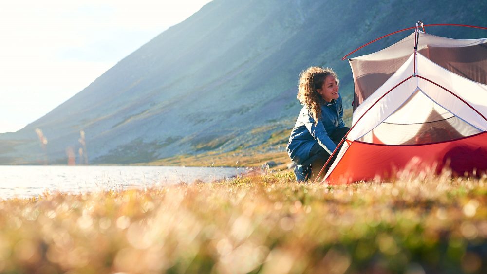 Woman putting up a tent in Norway