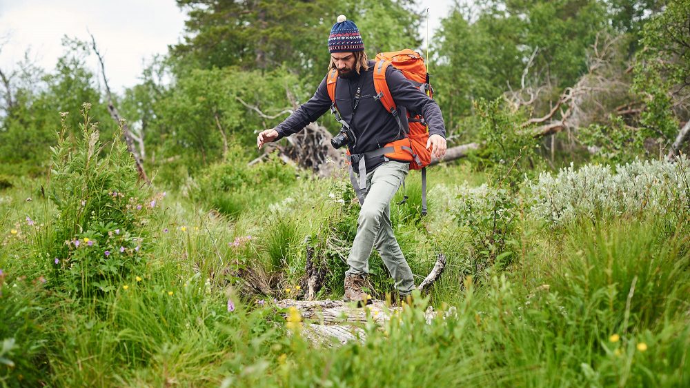 Hiker taking careful steps in a swamp in Norway