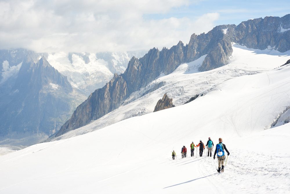 Group of alpinists walking down a snow slope in the Alps